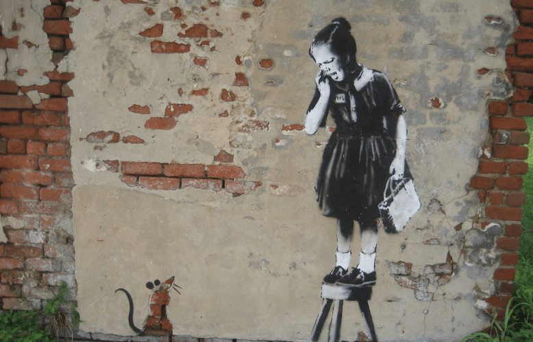 Rysunek na murze: dziewczynka stoi na taborecie i patrzy na stojącą na ziemi mysz.