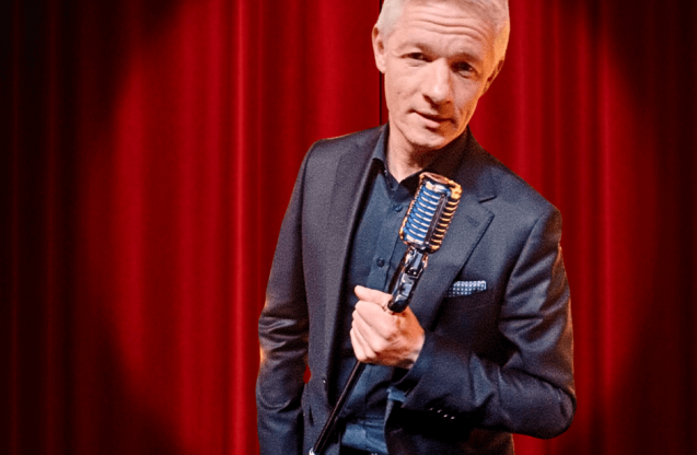 Mężczyzna z mikrofonem w ręku.