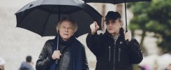 Dwóch mężczyzn pod czarnymi parasolami.