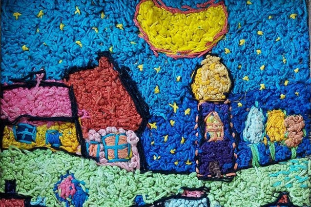 Tkana makatka z kolorowymi domkami i księżycem.